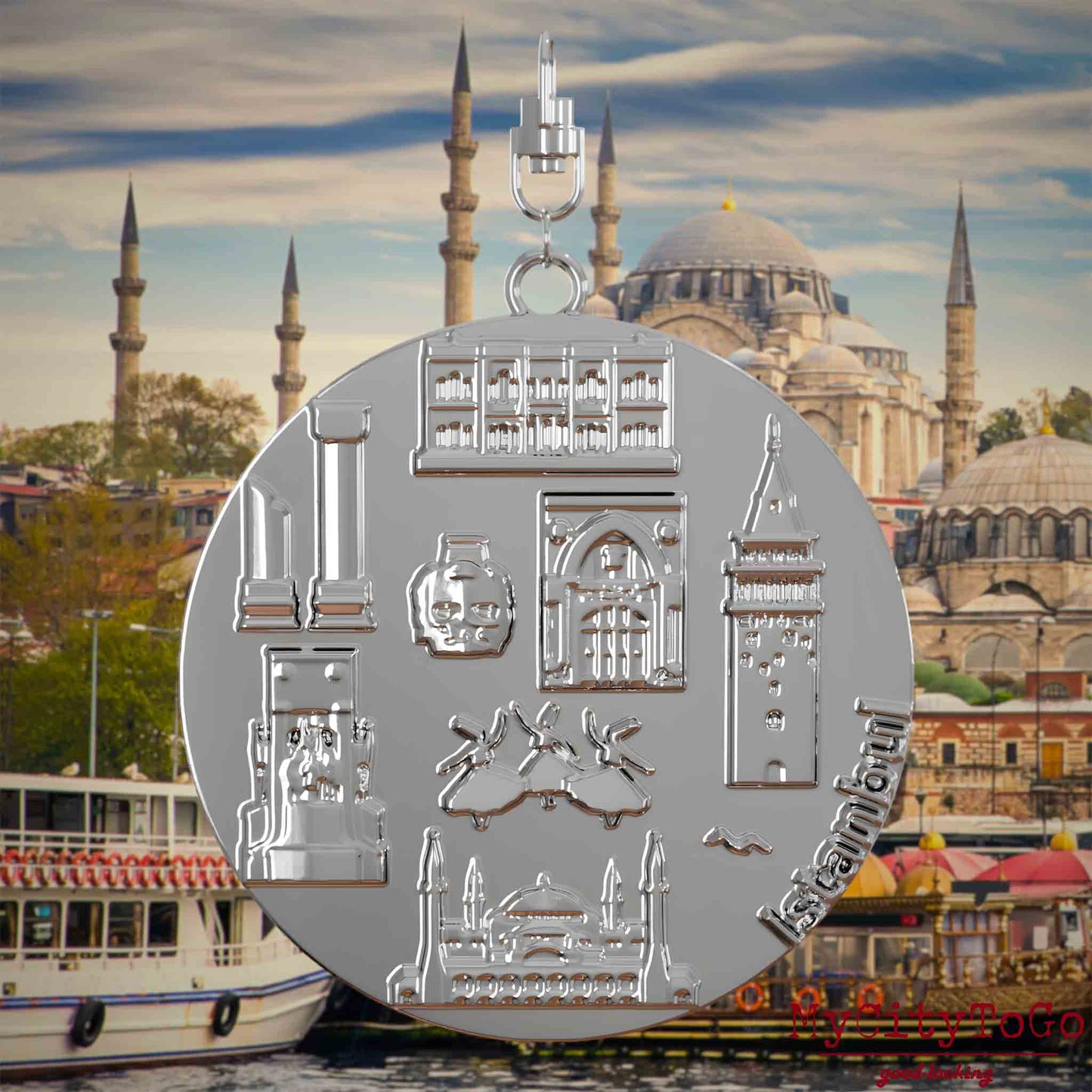 Halskette mit Drehwirbel und Rückseite eines silbernen Schmuckanhängers, auf dem Reliefs bekannter Sehenswürdigkeiten der Stadt Istanbul abgebildet sind. Den Hintergrund bildet eine Ansicht der Stadt Istanbul.