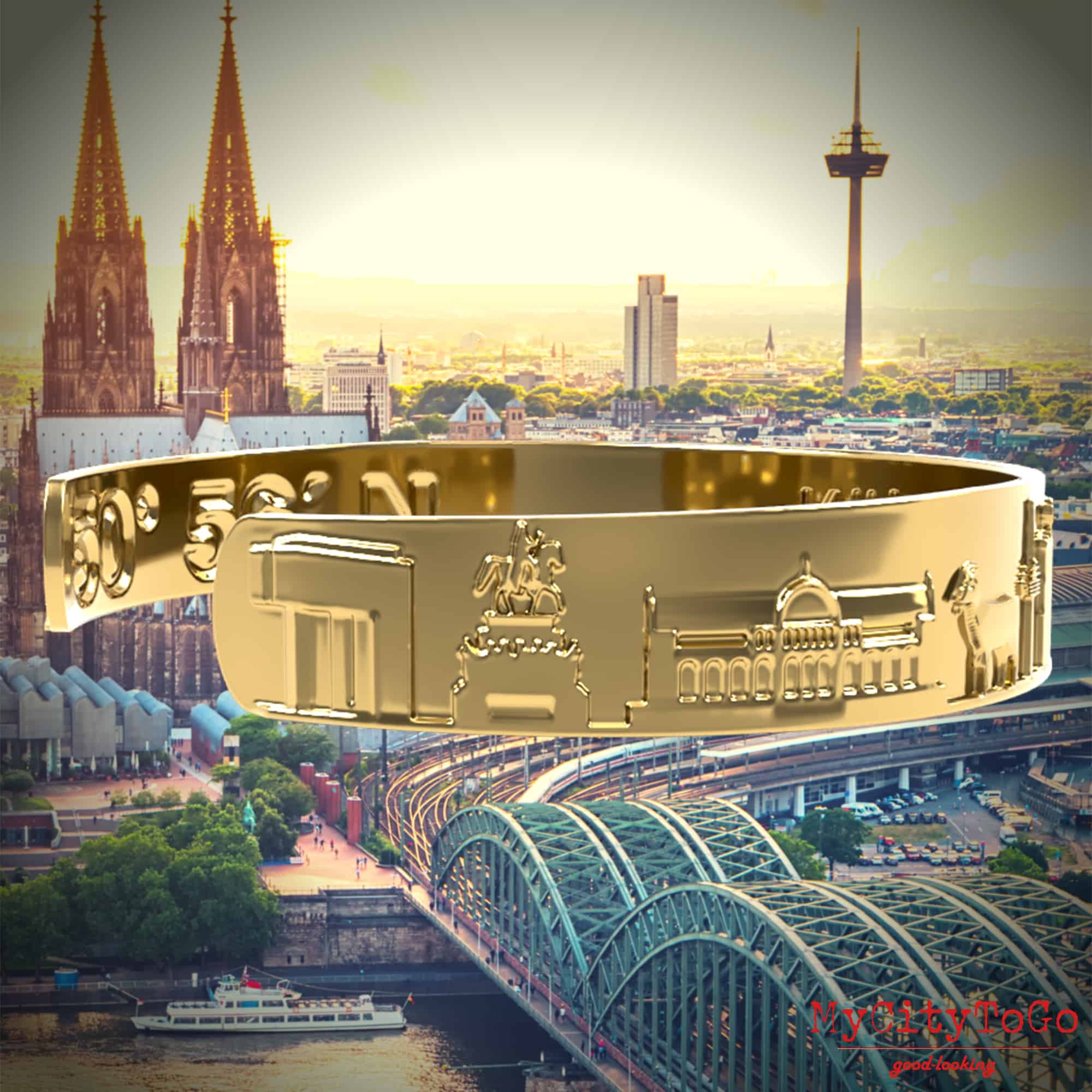 Goldfarbener Armreif mit Reliefs bekannter Motive der Stadt Köln