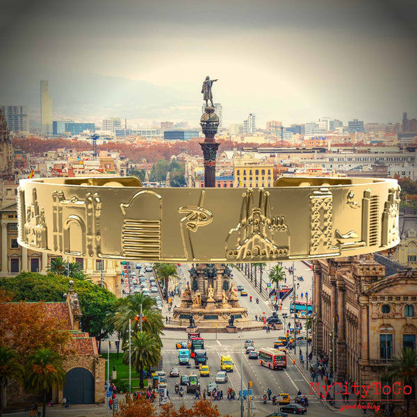Goldfarbener Armreif mit Reliefs bekannter Motive der Stadt Barcelona