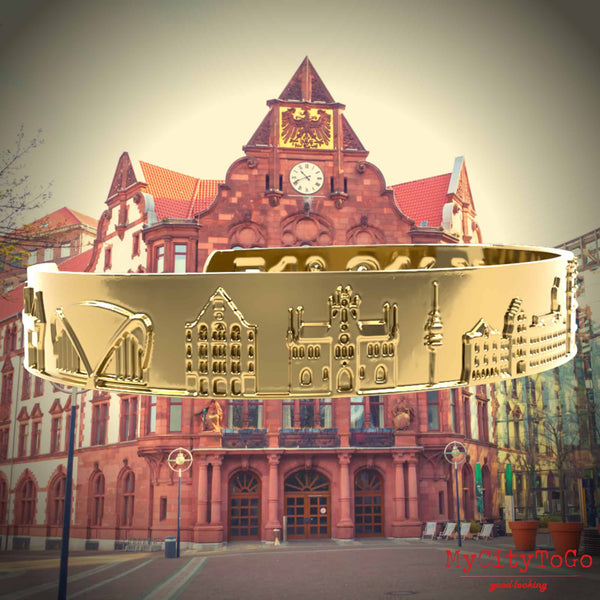A golden bracelet from MyCityToGo with famous motifs and coordinates of the German city Dortmund