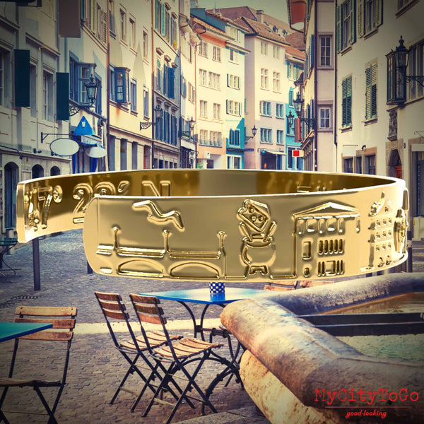 Goldfarbener Armreif mit Reliefs bekannter Motive der Stadt Zürich