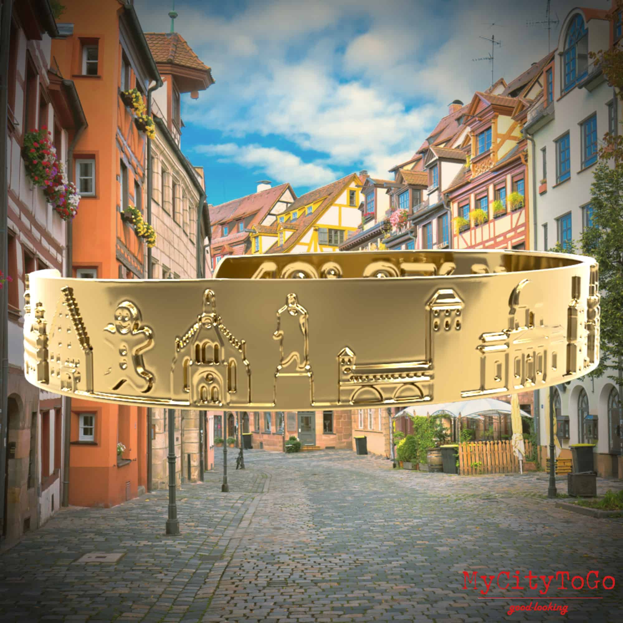 Goldfarbener Armreif mit Reliefs bekannter Motive der Stadt Nürnberg
