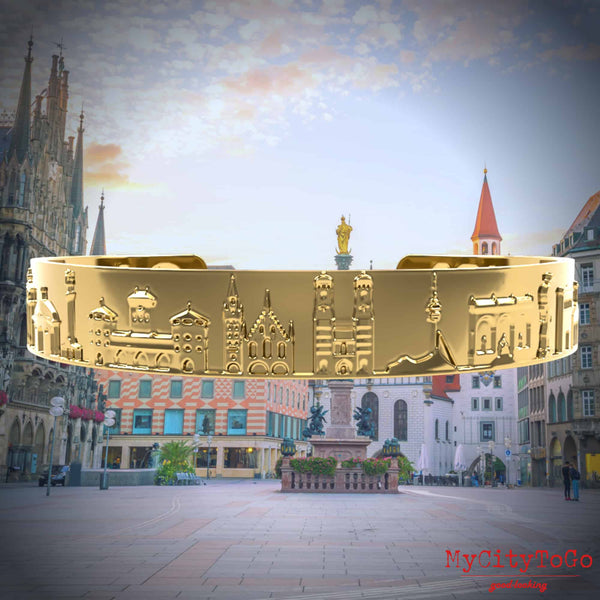 Goldfarbener Armreif mit Reliefs bekannter Motive der Stadt München