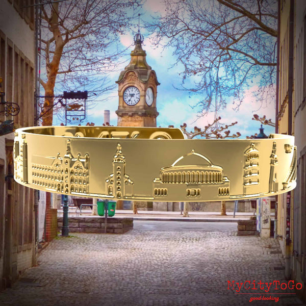 Goldfarbener Armreif mit Reliefs bekannter Motive der Stadt Düsseldorf