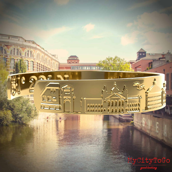 Goldfarbener Armreif mit Reliefs bekannter Motive der Stadt Leipzig