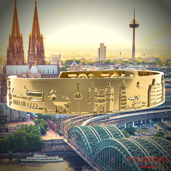 Goldfarbener Armreif mit Reliefs bekannter Motive der Stadt Köln