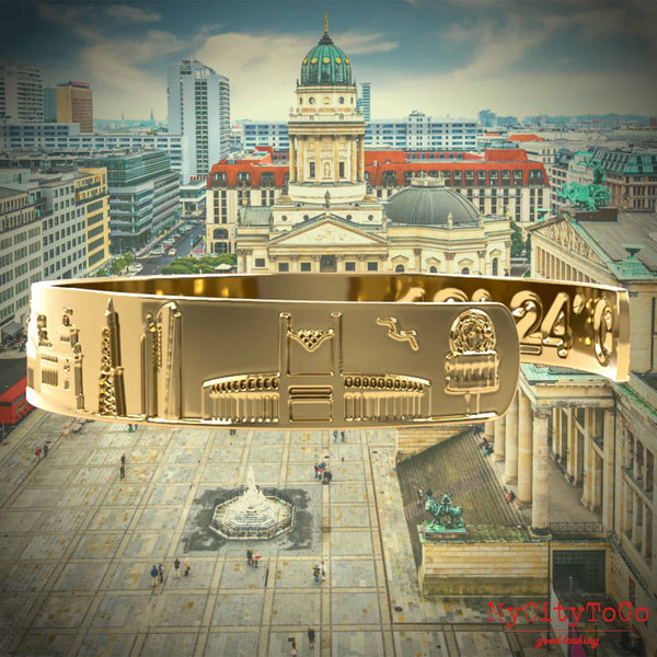 A golden bracelet from MyCityToGo with famous motifs and coordinates of the city of Berlin