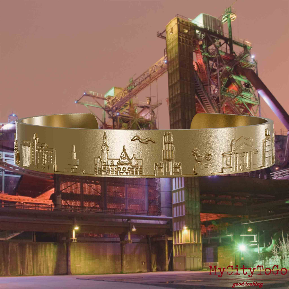 Bangle made of gold-plated stainless steel with reliefs of well-known landmarks of the city of Duisburg. The background features a view of the city of Duisburg.