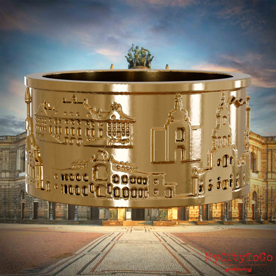 Vergoldeter Ring mit Reliefs bekannter Sehenswürdigkeiten der Stadt Dresden. Den Hintergrund bildet eine Ansicht der Stadt Dresden.