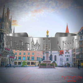 Armreif aus Edelstahl mit Reliefs bekannter Sehenswürdigkeiten der Stadt München. Den Hintergrund bildet eine Ansicht der Stadt Muenchen.