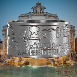 Ring aus Edelstahl mit Reliefs bekannter Sehenswürdigkeiten der Stadt Rom. Den Hintergrund bildet eine Ansicht der Stadt Rom.