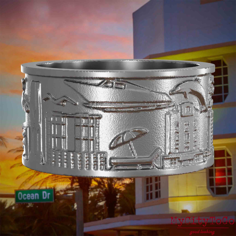 Ring aus Edelstahl mit Reliefs bekannter Sehenswürdigkeiten der Stadt Miami. Den Hintergrund bildet eine Ansicht der Stadt Miami.