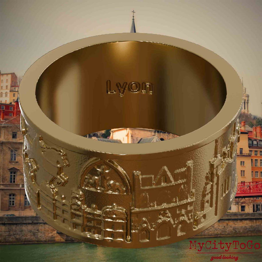 Ring aus vergoldetem Edelstahl mit Reliefs bekannter Sehenswürdigkeiten der Stadt Lyon und einer Gravur des Stadtnamens auf der Innenseite. Den Hintergrund bildet eine Ansicht der Stadt Lyon.