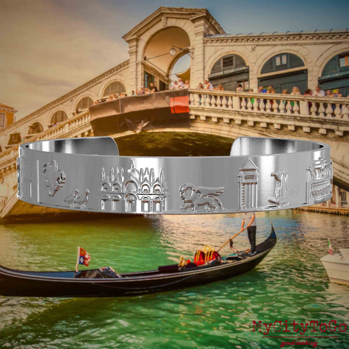 Versilberter Armreif mit Reliefs bekannter Sehenswürdigkeiten der Stadt Venedig. Den Hintergrund bildet eine Ansicht der Stadt Venedig.