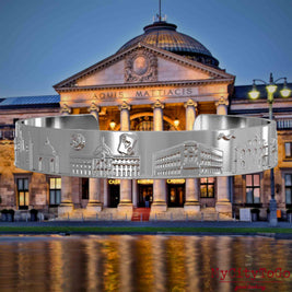 Silver-plated Bangle with reliefs of well-known landmarks in the city of Wiesbaden. The background features a view of the city of Wiesbaden.