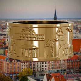 Vergoldeter Ring mit Reliefs bekannter Sehenswürdigkeiten der Stadt Hannover. Den Hintergrund bildet eine Ansicht der Stadt Hannover.