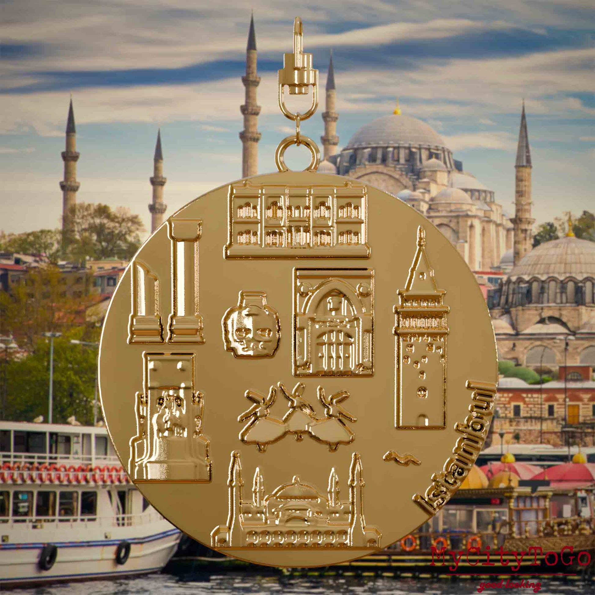 Halskette mit Drehwirbel und Rückseite eines vergoldeten Schmuckanhängers, auf dem Reliefs bekannter Sehenswürdigkeiten der Stadt Istanbul abgebildet sind. Den Hintergrund bildet eine Ansicht der Stadt Istanbul.

