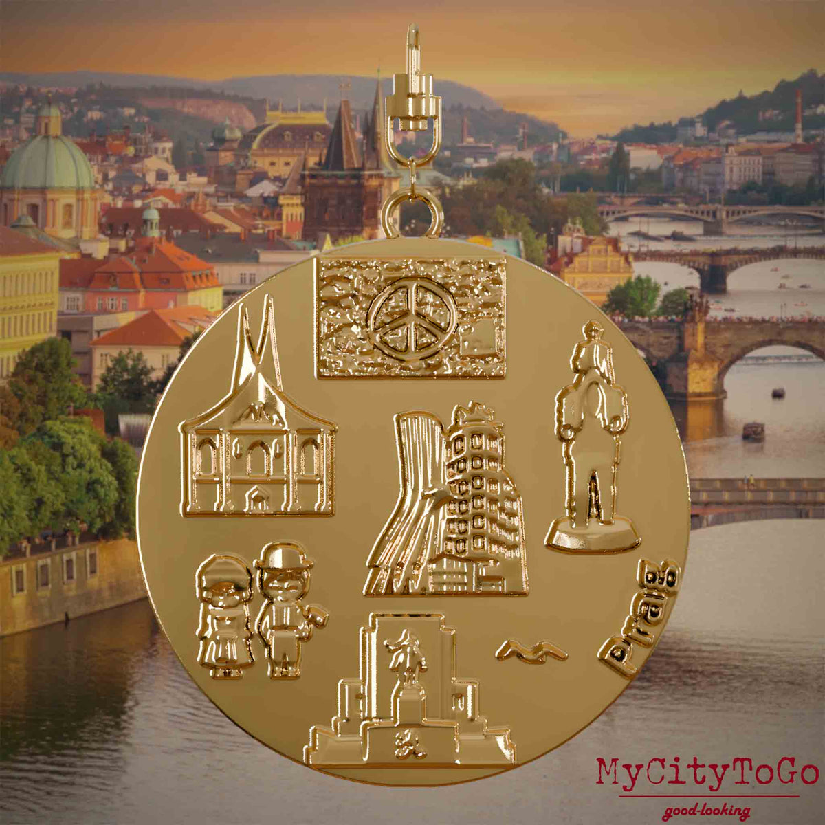Halskette mit Drehwirbel und Rückseite eines vergoldeten Schmuckanhängers, auf dem Reliefs bekannter Sehenswürdigkeiten der Stadt Prag abgebildet sind. Den Hintergrund bildet eine Ansicht der Stadt Prag.
