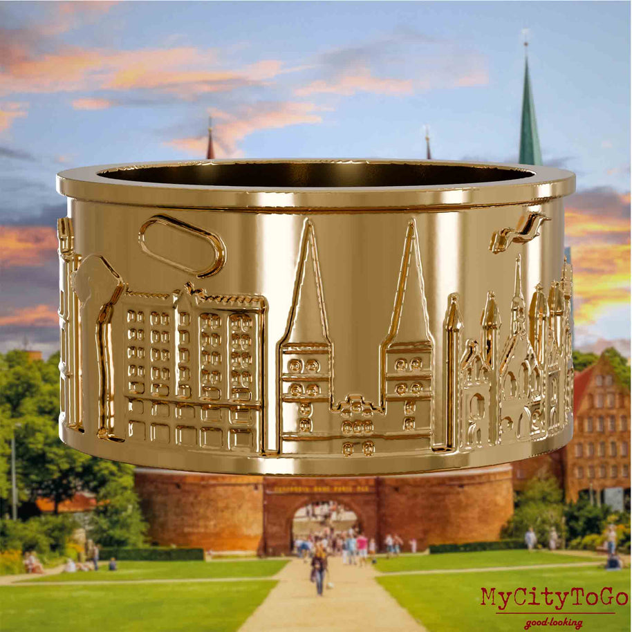 Vergoldeter Ring mit Reliefs bekannter Sehenswürdigkeiten der Stadt Luebeck. Den Hintergrund bildet eine Ansicht der Stadt Luebeck.