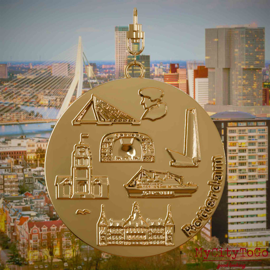 Halskette mit Drehwirbel und Rückseite eines vergoldeten Schmuckanhängers, auf dem Reliefs bekannter Sehenswürdigkeiten der Stadt Rotterdam abgebildet sind. Den Hintergrund bildet eine Ansicht der Stadt Rotterdam.
