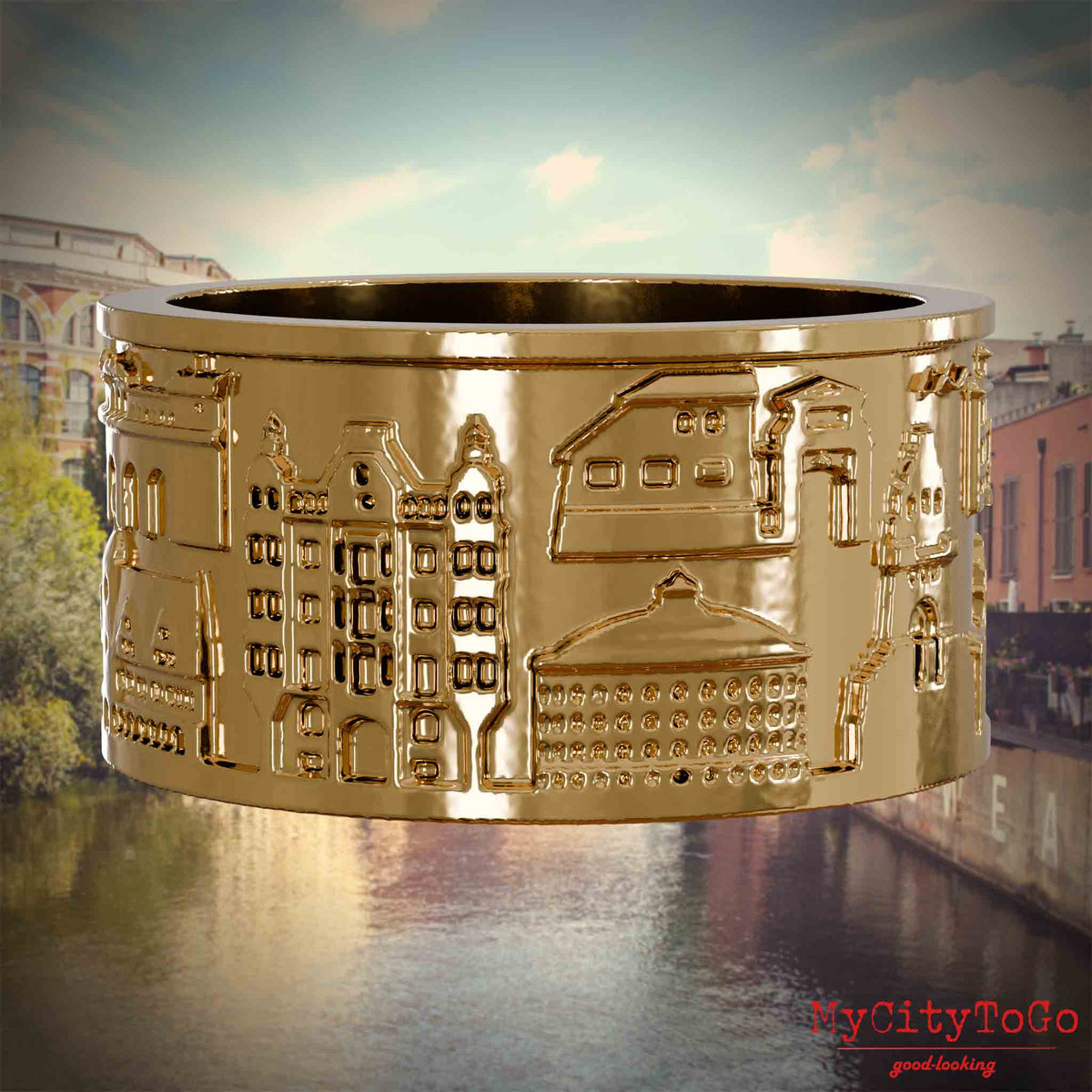 Vergoldeter Ring mit Reliefs bekannter Sehenswürdigkeiten der Stadt Leipzig. Den Hintergrund bildet eine Ansicht der Stadt Leipzig.
