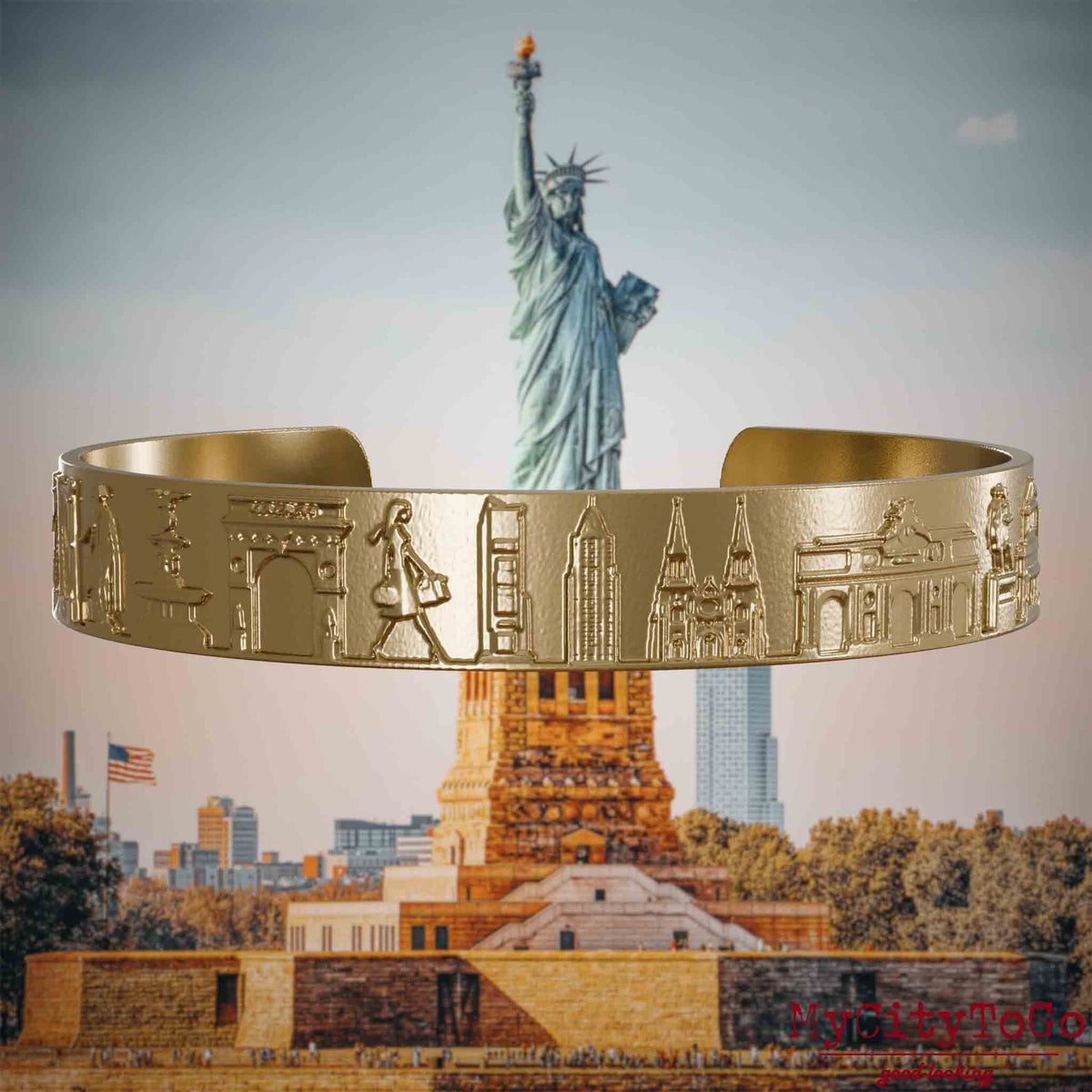 Armreif aus vergoldetem Edelstahl mit Reliefs bekannter Sehenswürdigkeiten der Stadt New York. Den Hintergrund bildet eine Ansicht der Stadt New York.