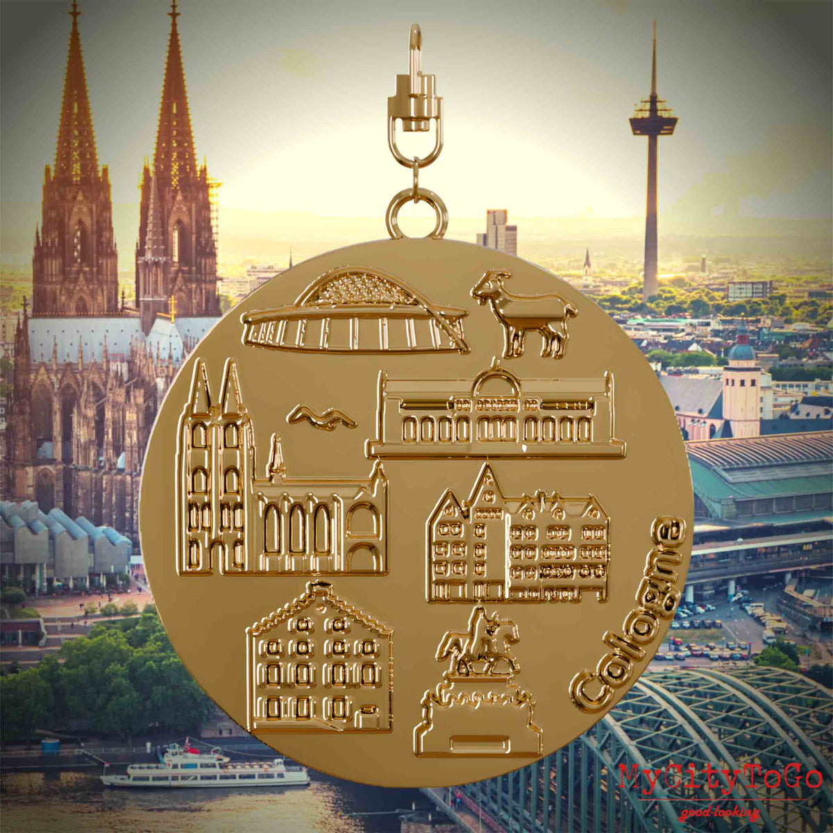 Halskette mit Drehwirbel und Vorderseite eines vergoldeten Schmuckanhängers, auf dem Reliefs bekannter Sehenswürdigkeiten der Stadt Koeln abgebildet sind. Den Hintergrund bildet eine Ansicht der Stadt Koeln.