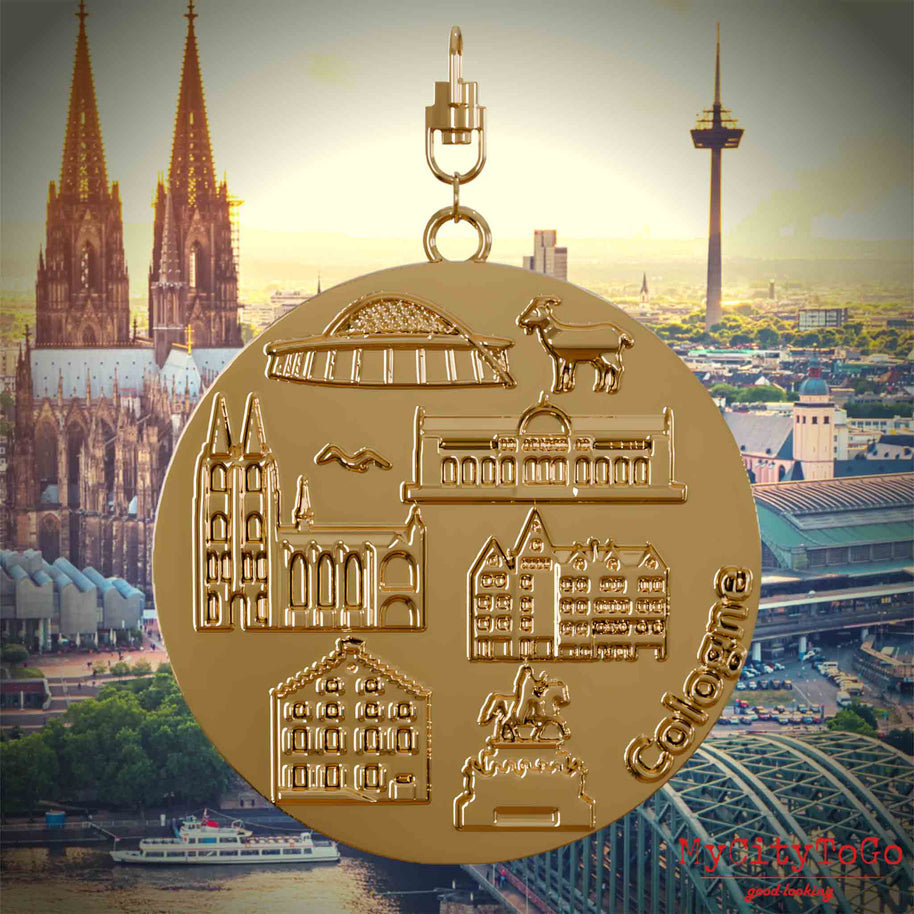 Halskette mit Drehwirbel und Vorderseite eines vergoldeten Schmuckanhängers, auf dem Reliefs bekannter Sehenswürdigkeiten der Stadt Koeln abgebildet sind. Den Hintergrund bildet eine Ansicht der Stadt Koeln.