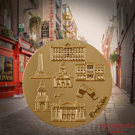 Halskette mit Drehwirbel und Vorderseite eines vergoldeten Schmuckanhängers, auf dem Reliefs bekannter Sehenswürdigkeiten der Stadt Dublin abgebildet sind. Den Hintergrund bildet eine Ansicht der Stadt Dublin.
