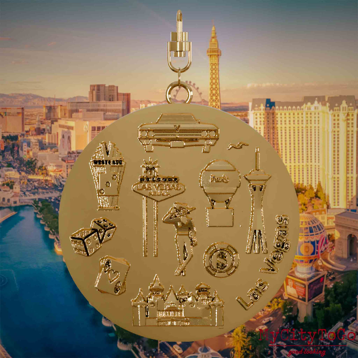 Necklace with swivel clasp and the back of a gold-plated pendant featuring reliefs of well-known landmarks in the city of Las Vegas. The background shows a view of the city of Las Vegas.