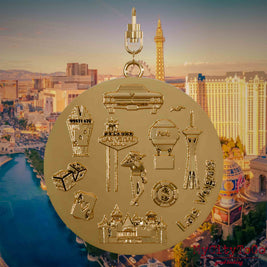 Necklace with swivel clasp and the back of a gold-plated pendant featuring reliefs of well-known landmarks in the city of Las Vegas. The background shows a view of the city of Las Vegas.