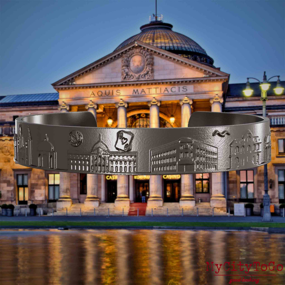 Bangle made of titanium with reliefs of well-known landmarks of the city of Wiesbaden. The background features a view of the city of Wiesbaden.