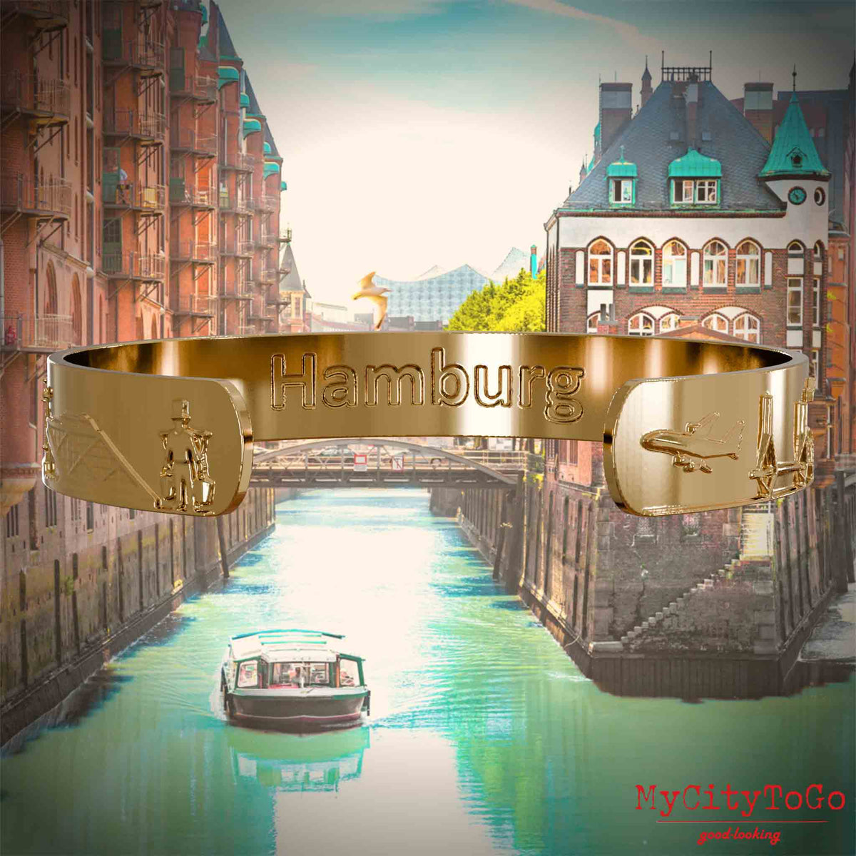 Inside of a gold-plated bangle with reliefs of well-known landmarks of the city of Hamburg and an engraving of the city's name. The background features a view of the city of Hamburg.