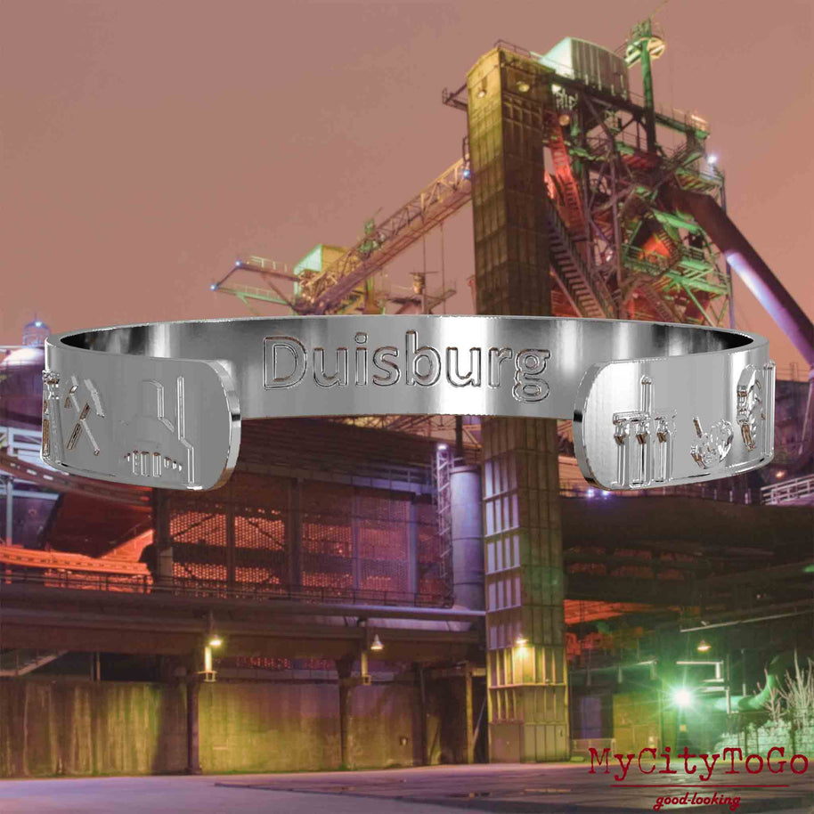 Interior of a silver bangle with reliefs of well-known landmarks in the city of Duisburg and an engraving of the city’s name. The background features a view of the city of Duisburg.