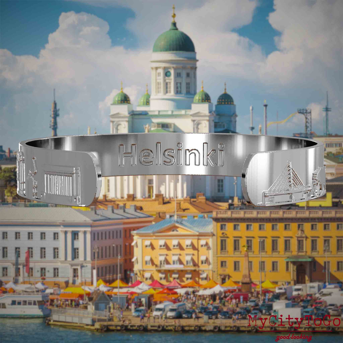Innenseite eines silbernen Armreifs mit Reliefs bekannter Sehenswürdigkeiten der Stadt Helsinki und einer Gravur des Stadtnamens. Den Hintergrund bildet eine Ansicht der Stadt Helsinki.