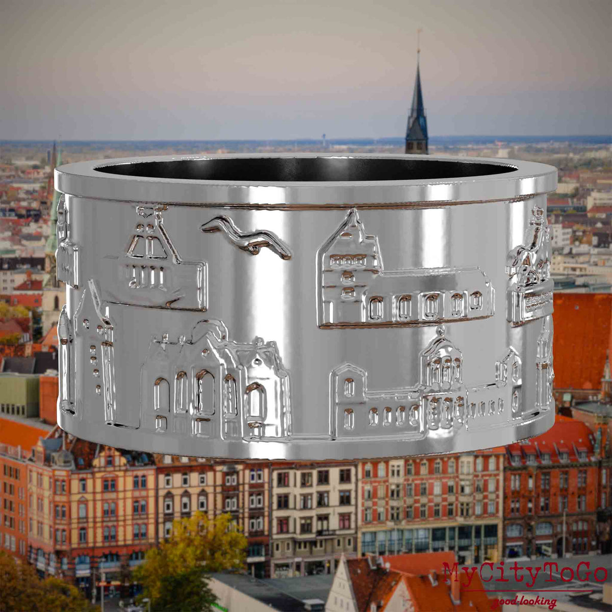 Silberner Ring mit Reliefs bekannter Sehenswürdigkeiten der Stadt Hannover. Den Hintergrund bildet eine Ansicht der Stadt Hannover.