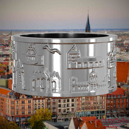 Silberner Ring mit Reliefs bekannter Sehenswürdigkeiten der Stadt Hannover. Den Hintergrund bildet eine Ansicht der Stadt Hannover.
