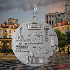 Halskette mit Drehwirbel und Vorderseite eines Schmuckanhängers aus Edelstahl, auf dem Reliefs bekannter Sehenswürdigkeiten der Stadt Lissabon abgebildet sind. Den Hintergrund bildet eine Ansicht der Stadt Lissabon.
