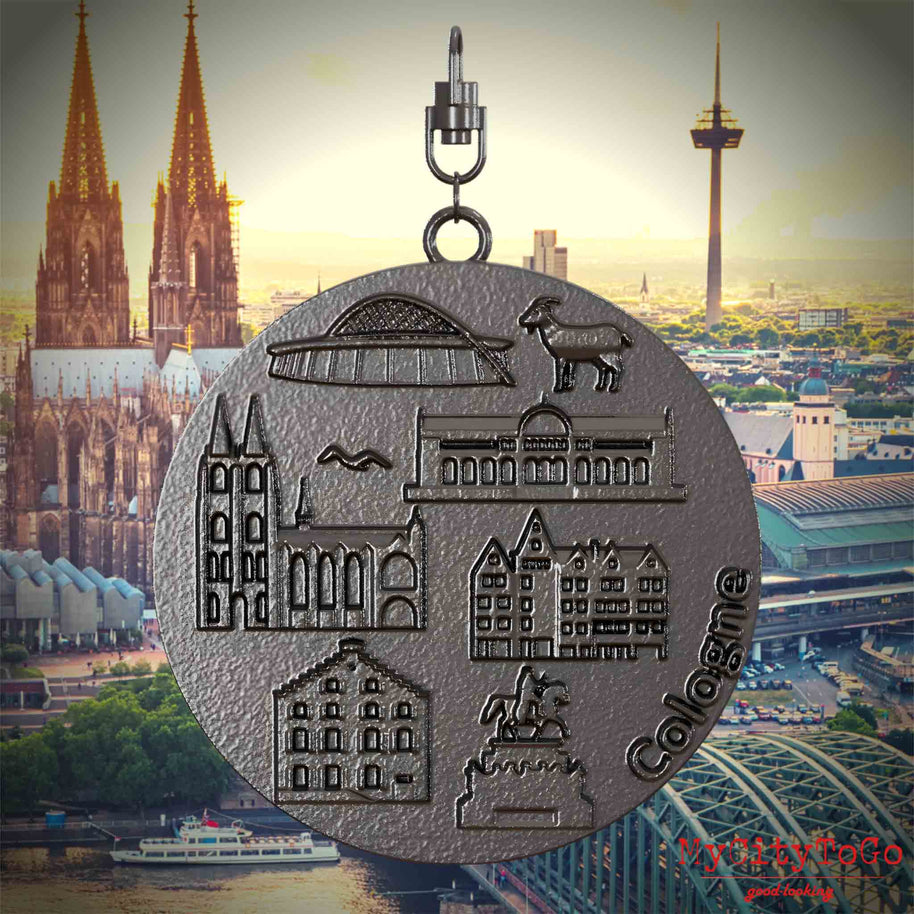 Halskette mit Drehwirbel und Vorderseite eines Schmuckanhängers aus Titan, auf dem Reliefs bekannter Sehenswürdigkeiten der Stadt Koeln abgebildet sind. Den Hintergrund bildet eine Ansicht der Stadt Koeln.