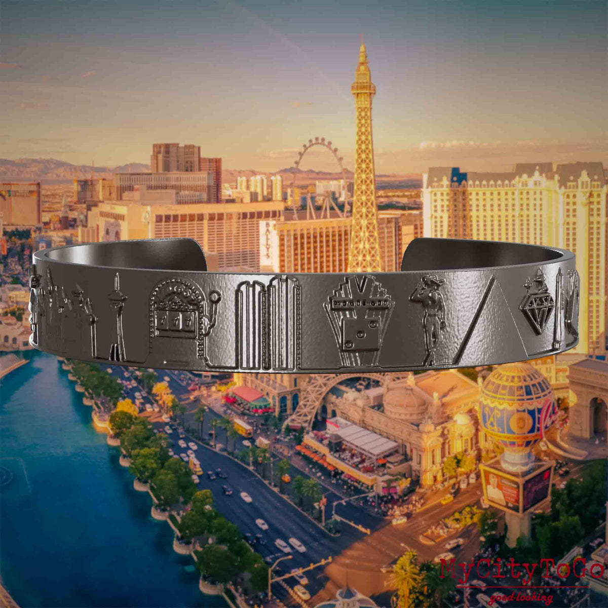 Armreif aus Titan mit Reliefs bekannter Sehenswürdigkeiten der Stadt Las Vegas. Den Hintergrund bildet eine Ansicht der Stadt Las Vegas.