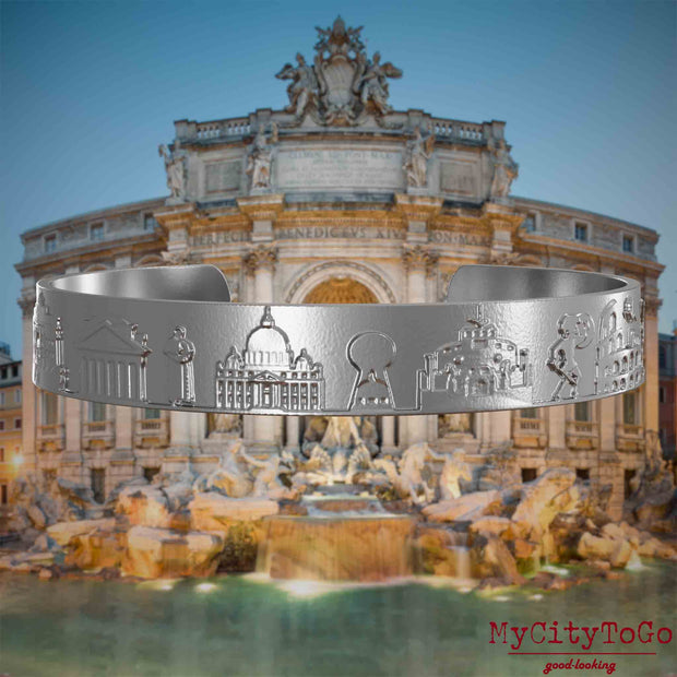 Armreif aus Edelstahl mit Reliefs bekannter Sehenswürdigkeiten der Stadt Rom. Den Hintergrund bildet eine Ansicht der Stadt Rom.
