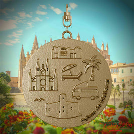 Halskette mit Drehwirbel und Rückseite eines Schmuckanhängers aus vergoldetem Edelstahl, auf dem Reliefs bekannter Sehenswürdigkeiten der Stadt Palma de Mallorca abgebildet sind. Den Hintergrund bildet eine Ansicht der Stadt Palma de Mallorca.

