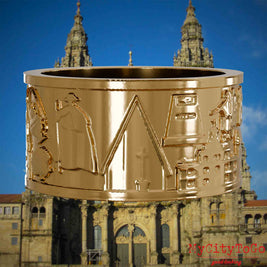 Vergoldeter Ring mit Reliefs bekannter Sehenswürdigkeiten und Wahrzeichen auf dem Jakobsweg. Den Hintergrund bildet die Kathedrale von Santiago de Compostela.