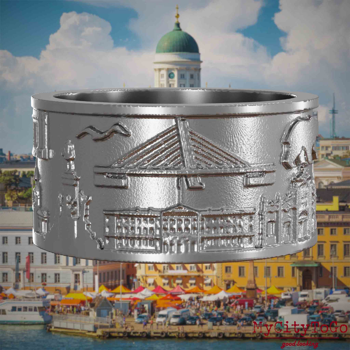 Ring aus Edelstahl mit Reliefs bekannter Sehenswürdigkeiten der Stadt Helsinki. Den Hintergrund bildet eine Ansicht der Stadt Helsinki.