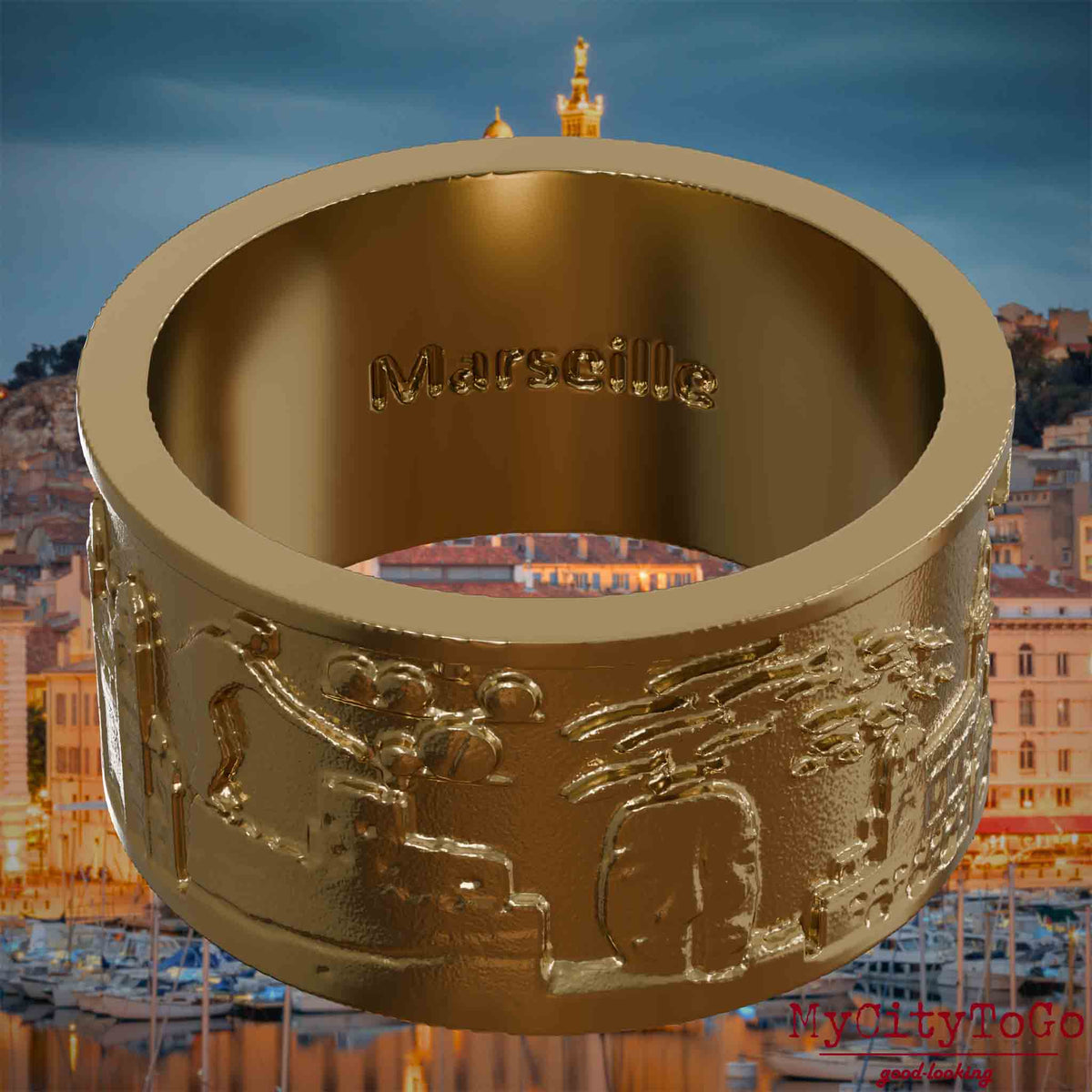 Ring aus vergoldetem Edelstahl mit Reliefs bekannter Sehenswürdigkeiten der Stadt Marseille und einer Gravur des Stadtnamens auf der Innenseite. Den Hintergrund bildet eine Ansicht der Stadt Marseille.