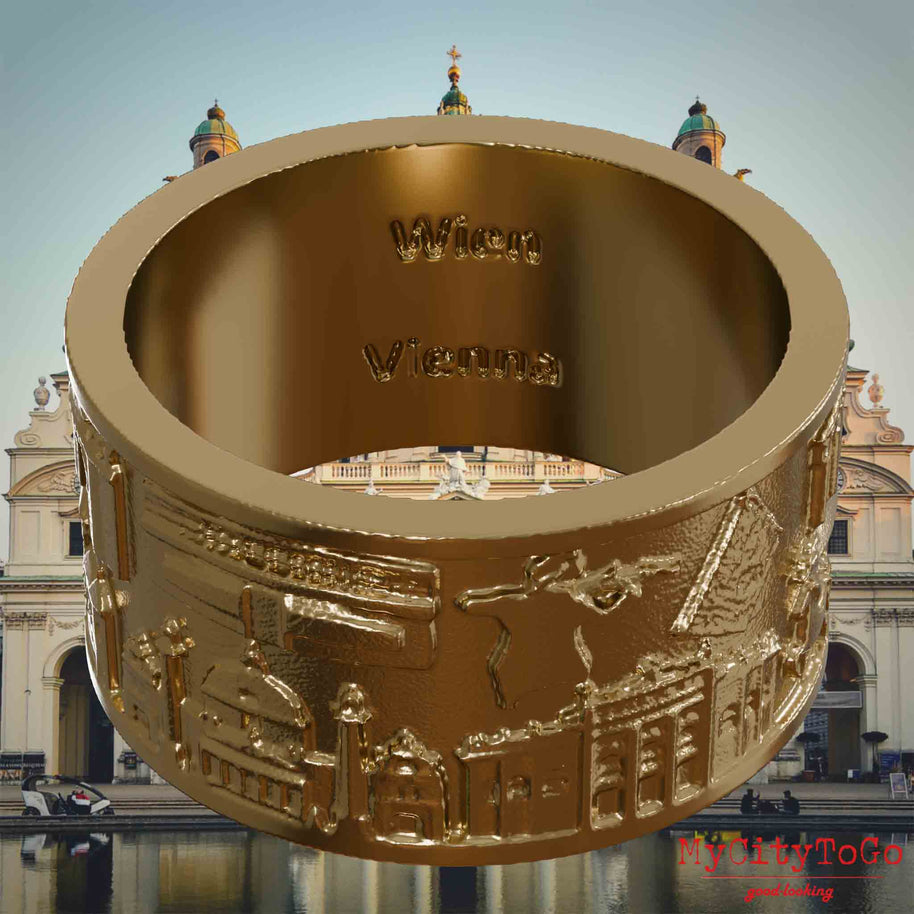 Ring aus vergoldetem Edelstahl mit Reliefs bekannter Sehenswürdigkeiten der Stadt Wien und einer Gravur des Stadtnamens auf der Innenseite. Den Hintergrund bildet eine Ansicht der Stadt Wien.