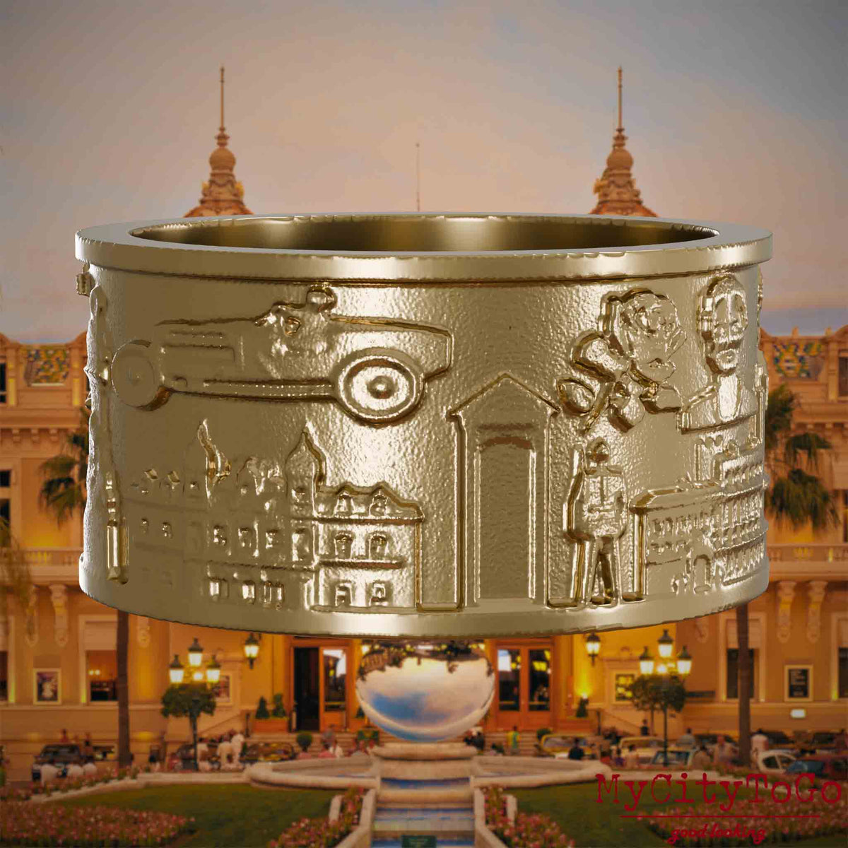 Ring aus vergoldetem Edelstahl mit Reliefs bekannter Sehenswürdigkeiten der Stadt Monte Carlo. Den Hintergrund bildet eine Ansicht der Stadt Monte Carlo.