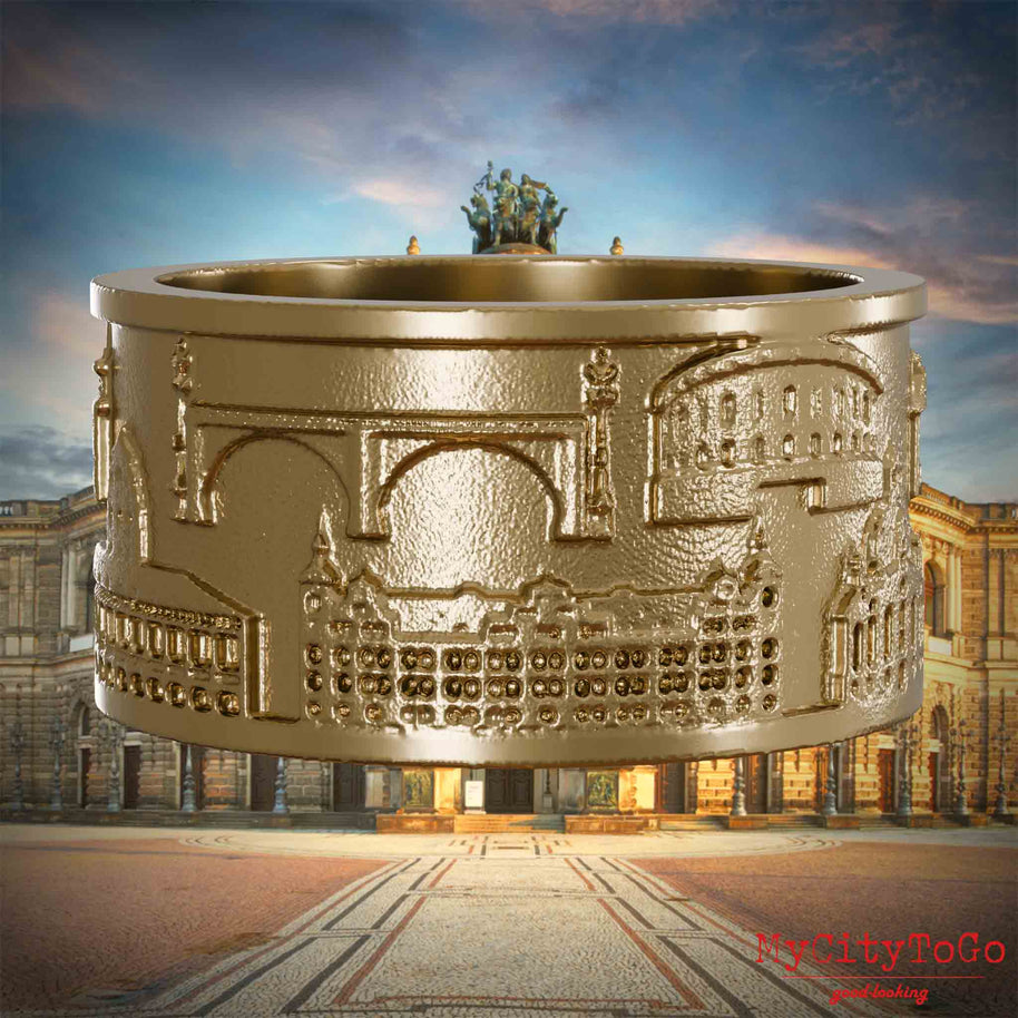 Ring aus vergoldetem Edelstahl mit Reliefs bekannter Sehenswürdigkeiten der Stadt Dresden. Den Hintergrund bildet eine Ansicht der Stadt Dresden.