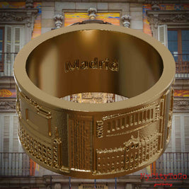 Ring aus vergoldetem Edelstahl mit Reliefs bekannter Sehenswürdigkeiten der Stadt Madrid und einer Gravur des Stadtnamens auf der Innenseite. Den Hintergrund bildet eine Ansicht der Stadt Madrid.