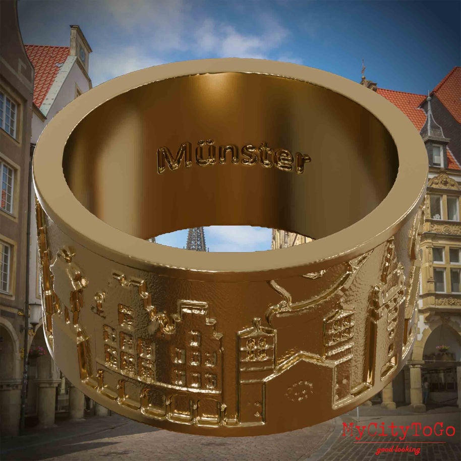 Ring aus vergoldetem Edelstahl mit Reliefs bekannter Sehenswürdigkeiten der Stadt Muenster und einer Gravur des Stadtnamens auf der Innenseite. Den Hintergrund bildet eine Ansicht der Stadt Muenster.